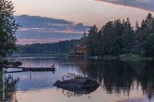Forest lake with footbridges, stones reflects the setting sun of Karelia  © alexkazachok
