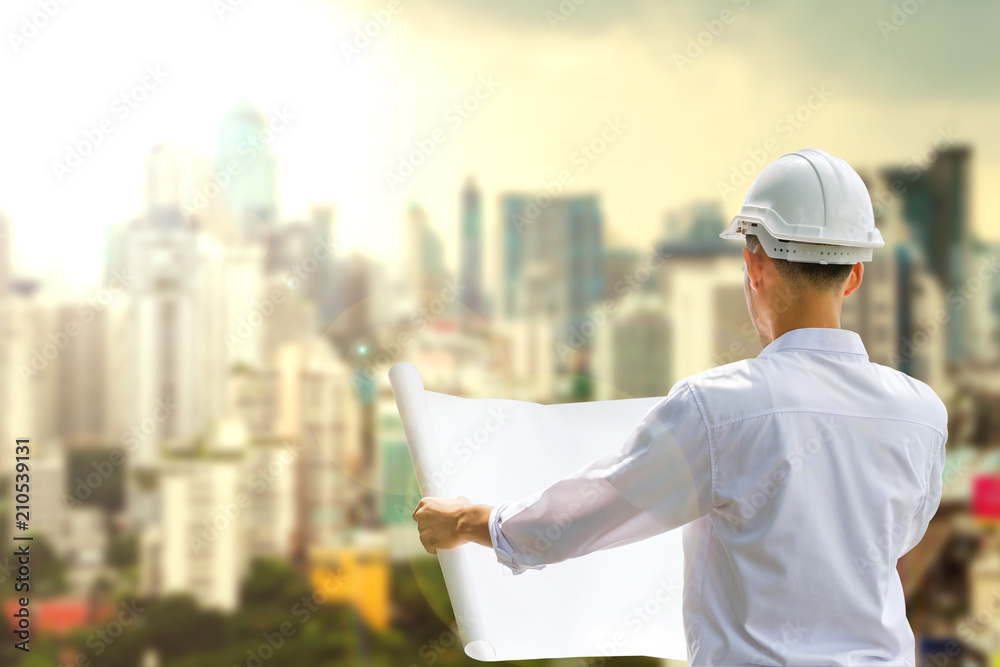 Structural engineers are going to be drafted on white paper,on the big city background at sunrise. Structural engineers are going to be drafted on white paper,on the big city background at sunrise.