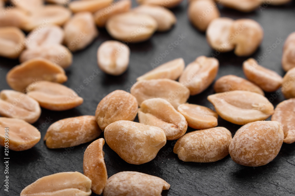 fresh peanuts on a dark stone background fresh peanuts on a dark stone background