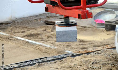 A pavement stone is lifted with vacuum, this unit can lift weights up to 60 kilos.