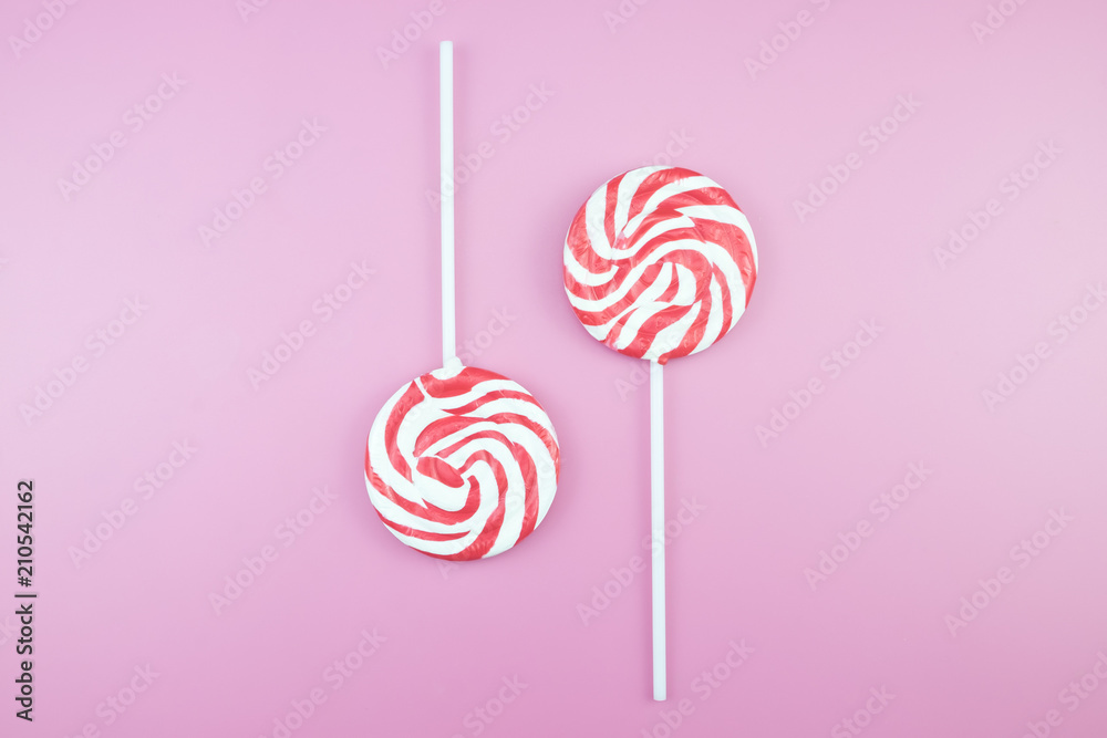 Flat lay top view tasty appetizing concept, minimal Sweet Treat Swirl Candy Lollipop marshmallow Colorful pattern on pink pastel background and copy space. Flat lay top view tasty appetizing concept, minimal Sweet Treat Swirl Candy Lollipop marshmallow Colorful pattern on pink pastel background and copy space.
