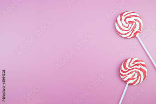 Flat lay top view tasty appetizing concept, minimal Sweet Treat Swirl Candy Lollipop marshmallow Colorful pattern on pink pastel background and copy space.