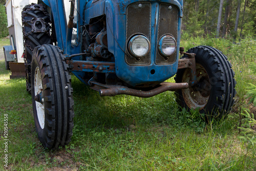 tires on a blue tractor standing i gras photo