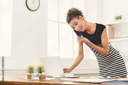 Smiling business woman at work talking on phone