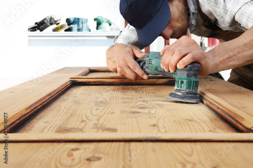 carpenter work the wood with the sander