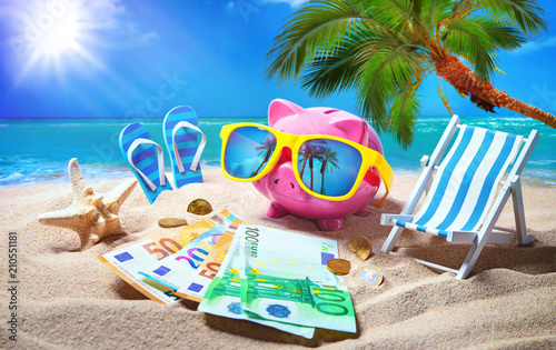 Fototapeta Naklejka Na Ścianę i Meble -  Piggy bank with sunglasses relax on the beach holiday