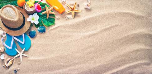 Straw hat with a exotic cocktail and sunglasses on sand beach