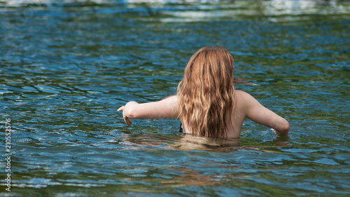 portrait of redhead girls swimming in the lake on back view