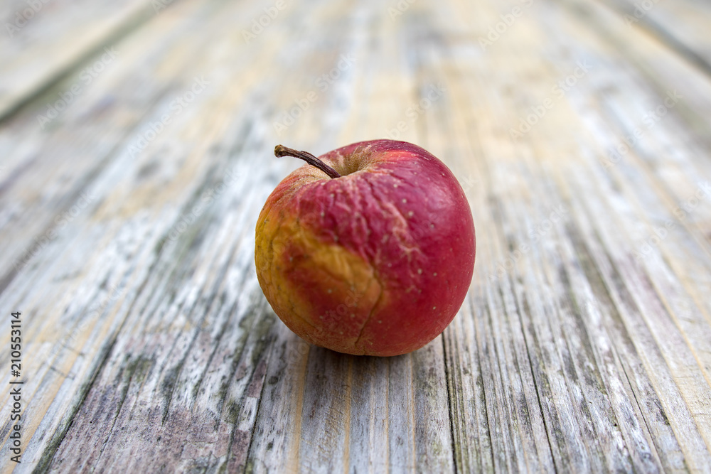 Alter, schrumpeliger Apfel auf Holztisch Alter, schrumpeliger Apfel auf Holztisch
