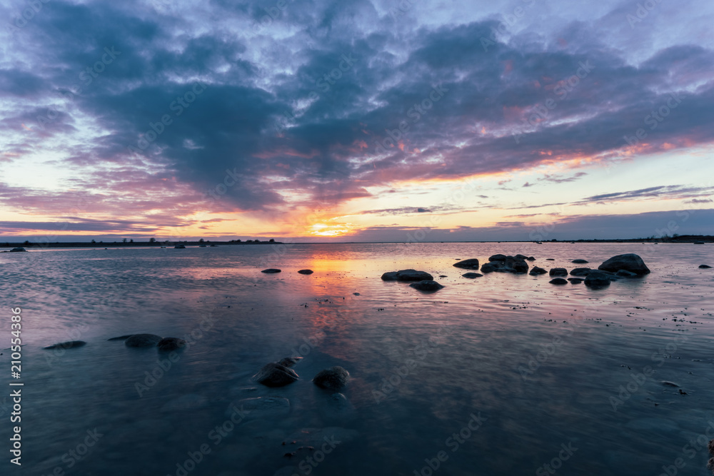 Naklejka premium Cloudy sunset by the ocean