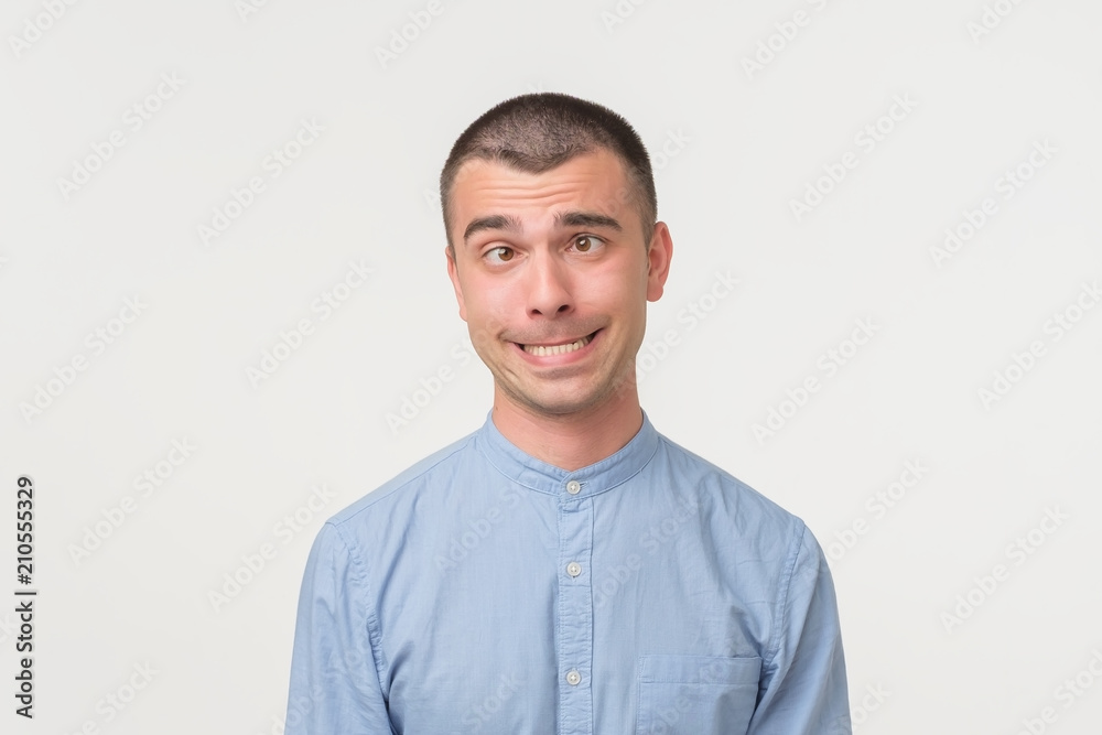 Handsome latino man shows surprised smile grimace or facial expression, isolated on white background. Handsome latino man shows surprised smile grimace or facial expression, isolated on white background.