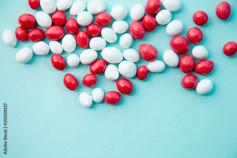 Red and white candy on blue background. Above view Red and white candy on blue background. Above view