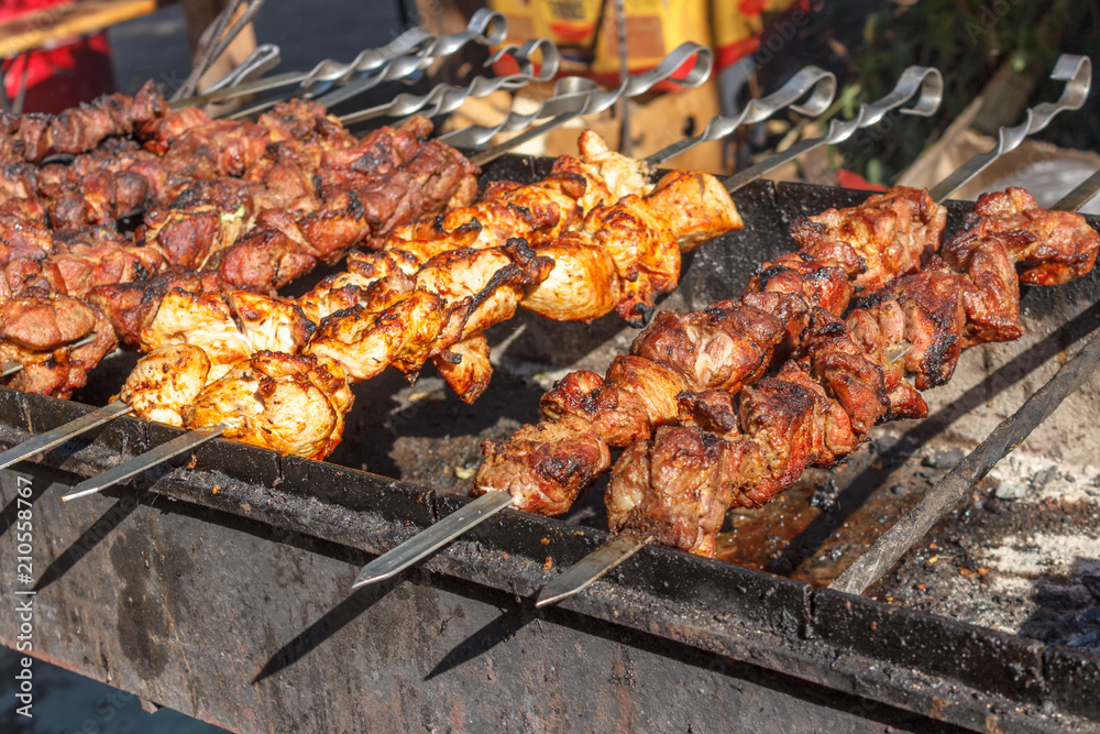 process of cooking meat on skewers on the grill
