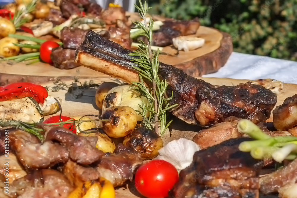 Grilled meat with grilled vegetables and spices on a wooden table. Grilled meat with grilled vegetables and spices on a wooden table.