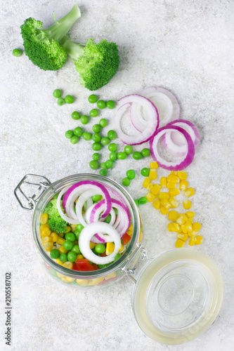 Healthy homemade vegetable salad in mason jars on light background