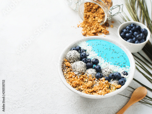 Blue smothie in bowl with granola and berries