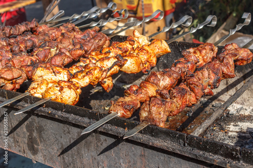 process of cooking meat on skewers on the grill