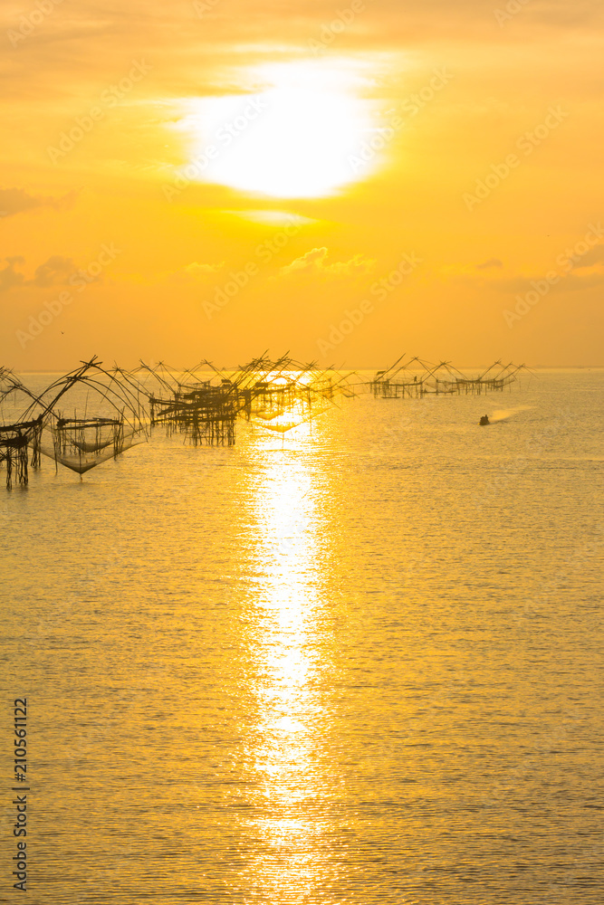 golden sky above fishing trap in Pak Pra Talay Noi sea Phatthalung south of Thailand