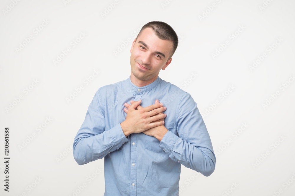 Kind spanish man in blue shirt with pleased expression looking into camera Kind spanish man in blue shirt with pleased expression looking into camera