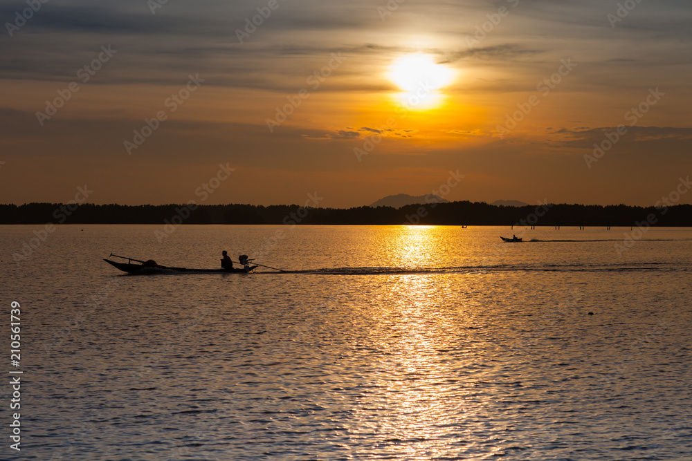 Colorful of sunset timing reflection on sea with longboat foreground 
