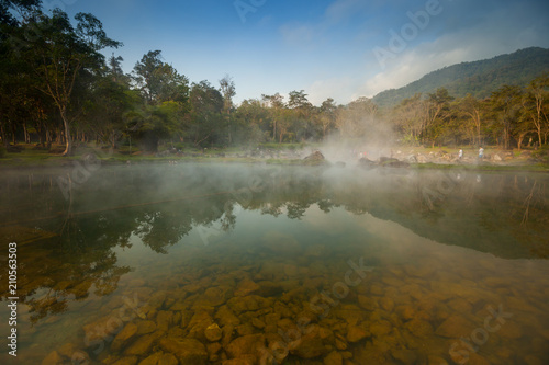 A natural fountain of clear water in morning time with cloudy foggy located in front of mountain at north of Thailand. Concept of healthy place 