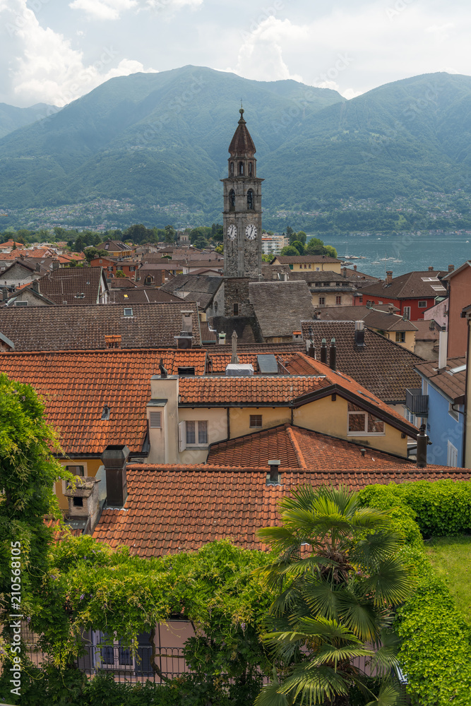 View over the rooftops of Ascona. Church and mountains in the background.