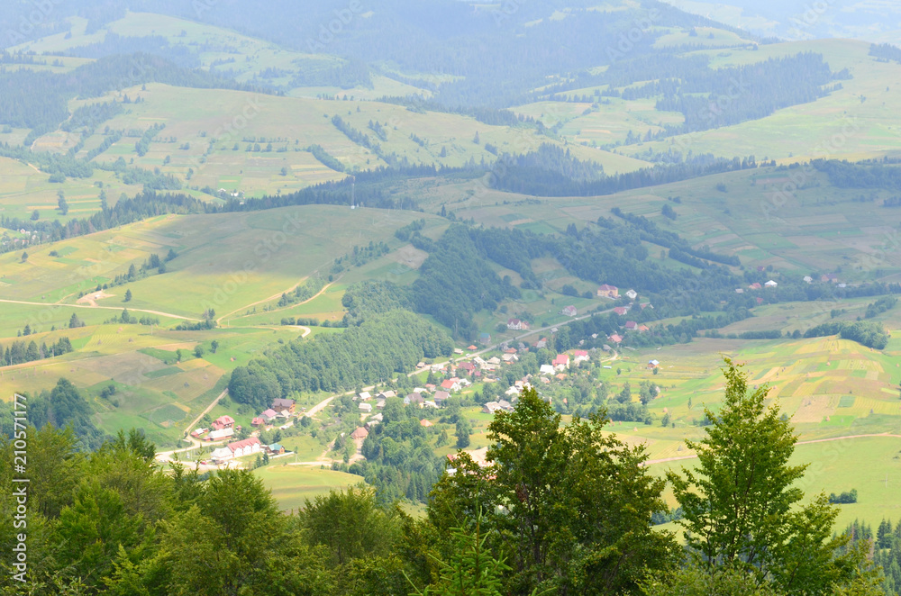 Outstanding landscape from a height. Green forest and village in the mountains. Ukrainian Carpathians