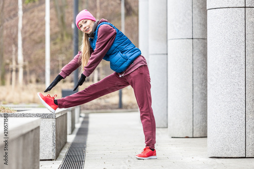 Sporty girl stretching outdoor on city street.