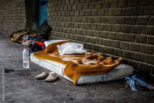 Obraz na płótnie Front view of homeless men bed and an orange blanket. Belongings in the front. w salonie