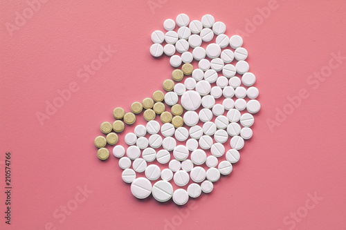 Kidney made of pills on pink background. World Kidney Day concept