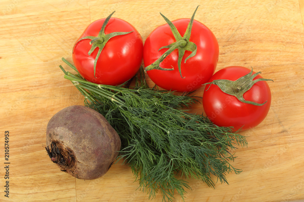 Beetroot, three ripe tomatoes and bunch of the fresh dill leaves on a cutting board Beetroot, three ripe tomatoes and bunch of the fresh dill leaves on a cutting board