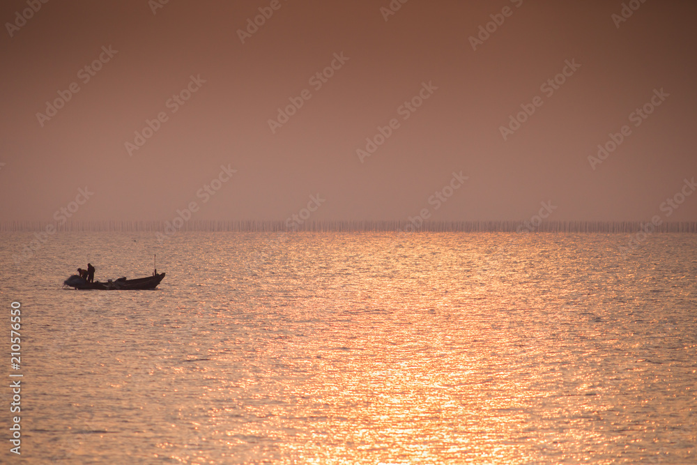Colorful of sunset is reflection on surface water with boat located at Chonburi thailand