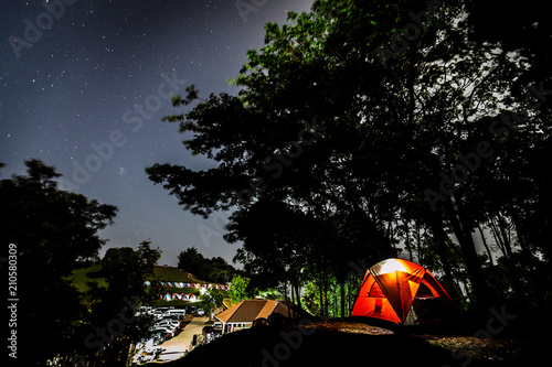 Camping tent at night under clear stars on sky 