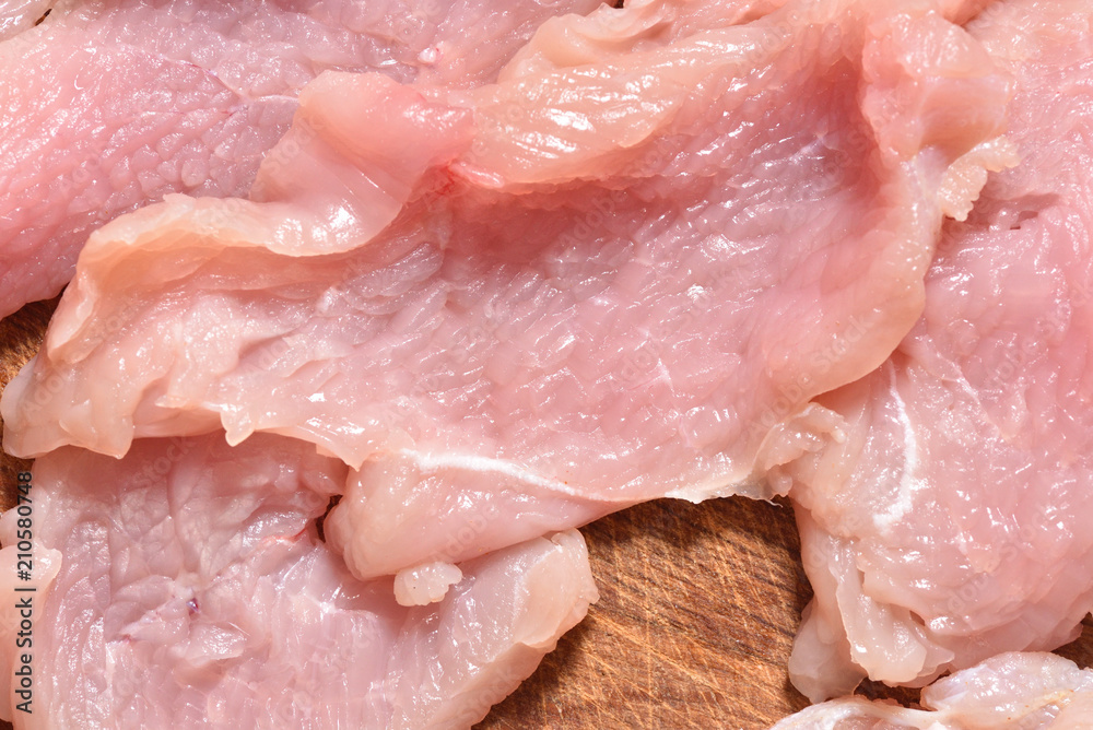 Raw and sliced turkey meat. Fresh pink turkey meat, close-up Raw and sliced turkey meat. Fresh pink turkey meat, close-up