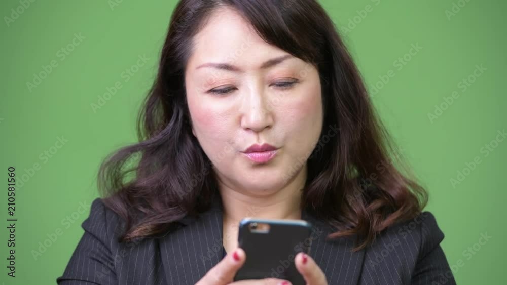 Mature beautiful Asian businesswoman using phone Mature beautiful Asian businesswoman using phone