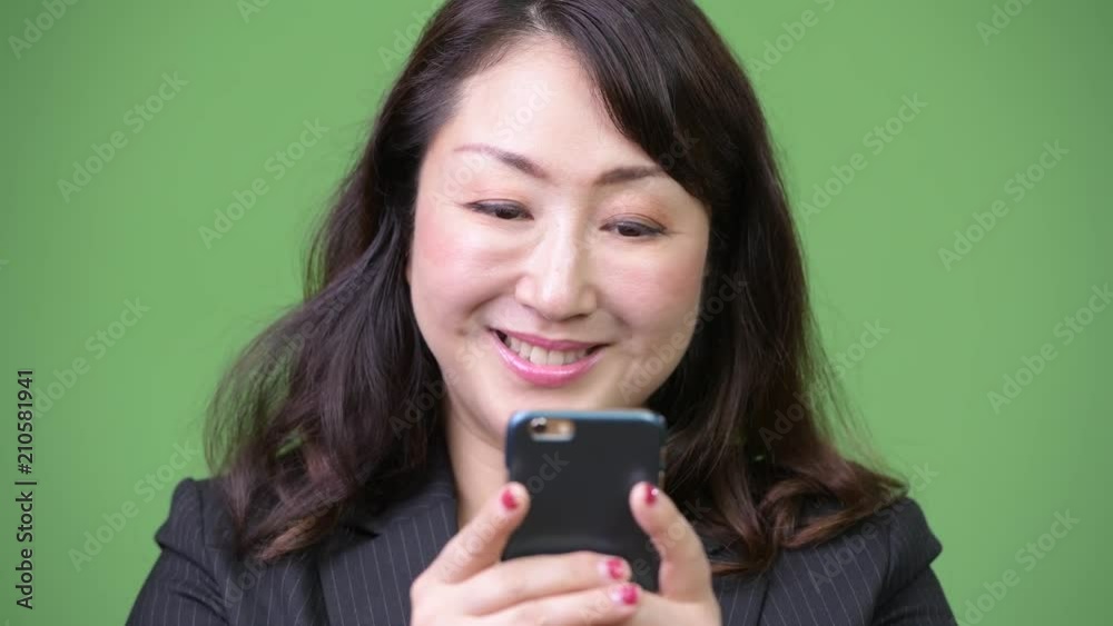 Mature beautiful Asian businesswoman using phone Mature beautiful Asian businesswoman using phone