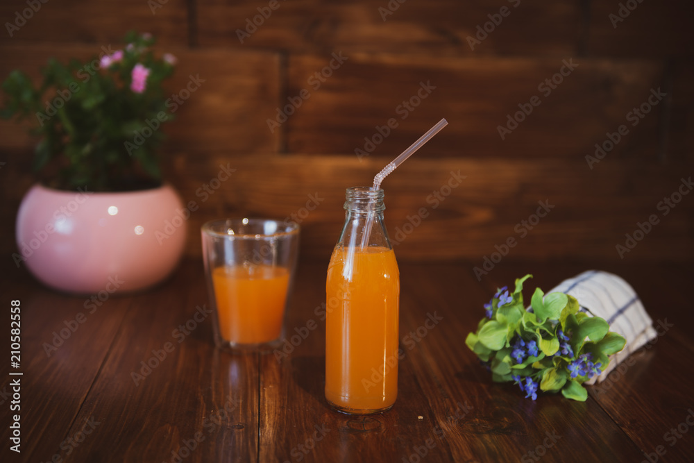 Fresh juice in bottle on wooden table