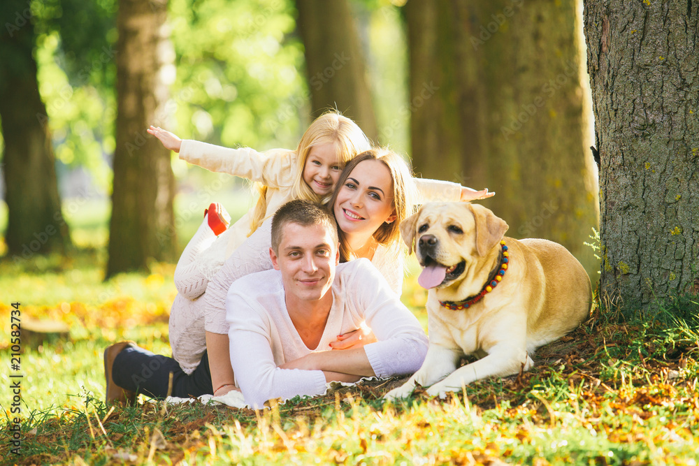 Fototapeta premium Happy family with their dog in the park on a sunny day