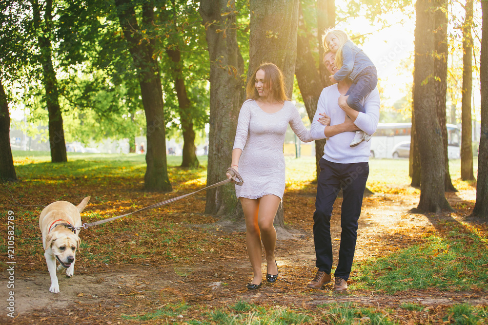 Obraz premium Happy family with their dog in the park on a sunny day