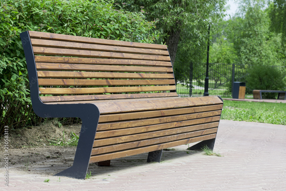 wooden brown bench in the summer green sunny forest park wooden brown bench in the summer green sunny forest park
