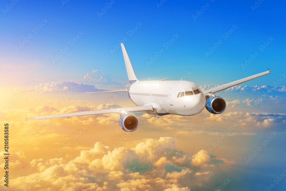 Passenger airplane flies in the sky against the background clouds during sunset. Passenger airplane flies in the sky against the background clouds during sunset.
