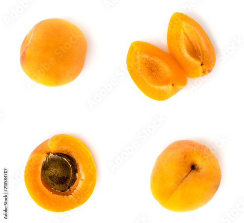 Ripe apricots on a white, half with a bone, whole and pieces. Isolated, top view.