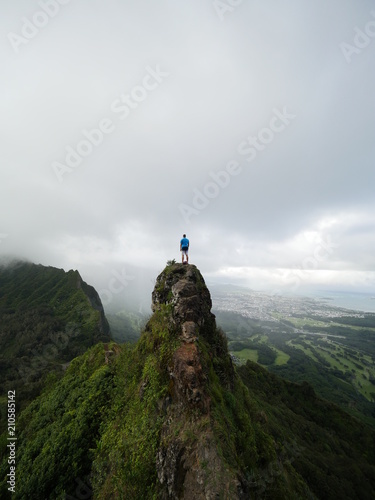person standing on top of a mountain peak in hawaii
