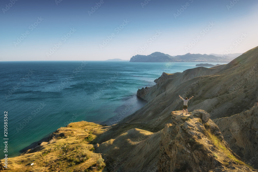 Man hiker standing on a cliffs edge