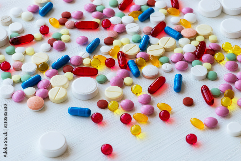 Many colorful medicines. Pills and capsules on white background.