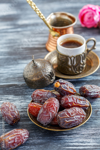 Dates on the plate, copper cezve and black coffee.