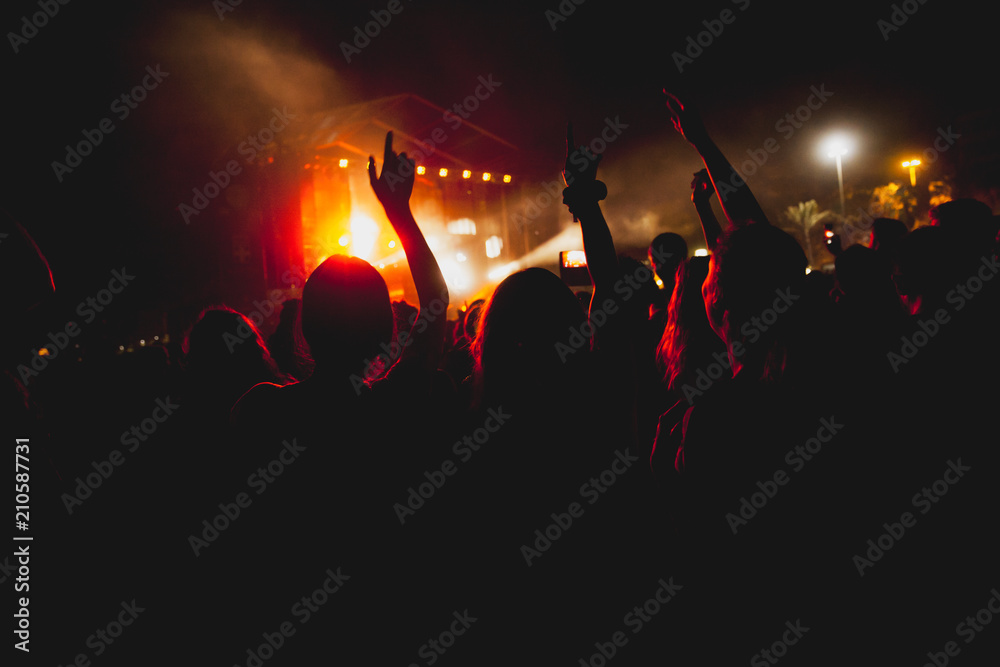 View of a concert with people or audience with hands in the air and clapping at a music festival. Summer music festival.