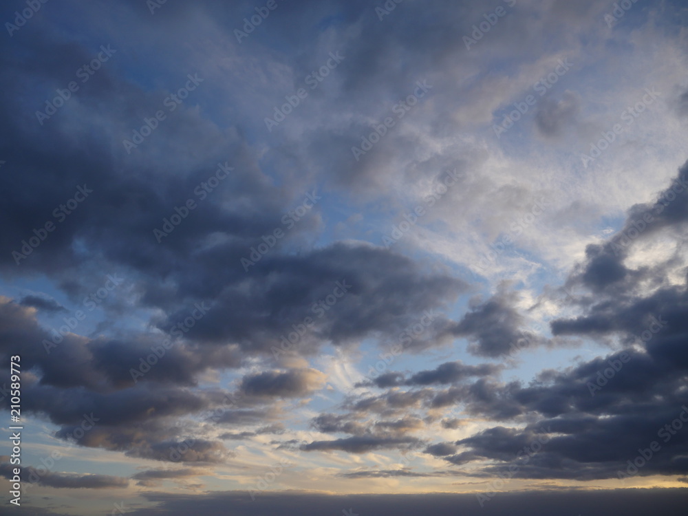 Dramatic cloudscape with gray clouds and blue sky during sunset 