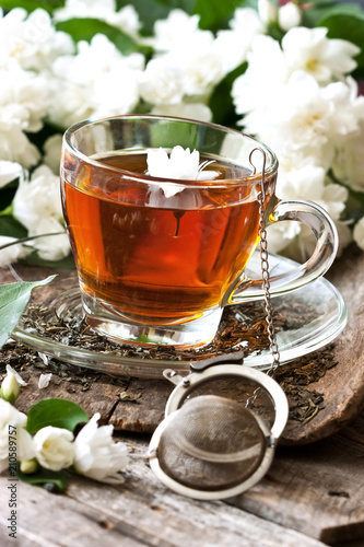 Composition cup of tea and jasmine flowers on wooden background