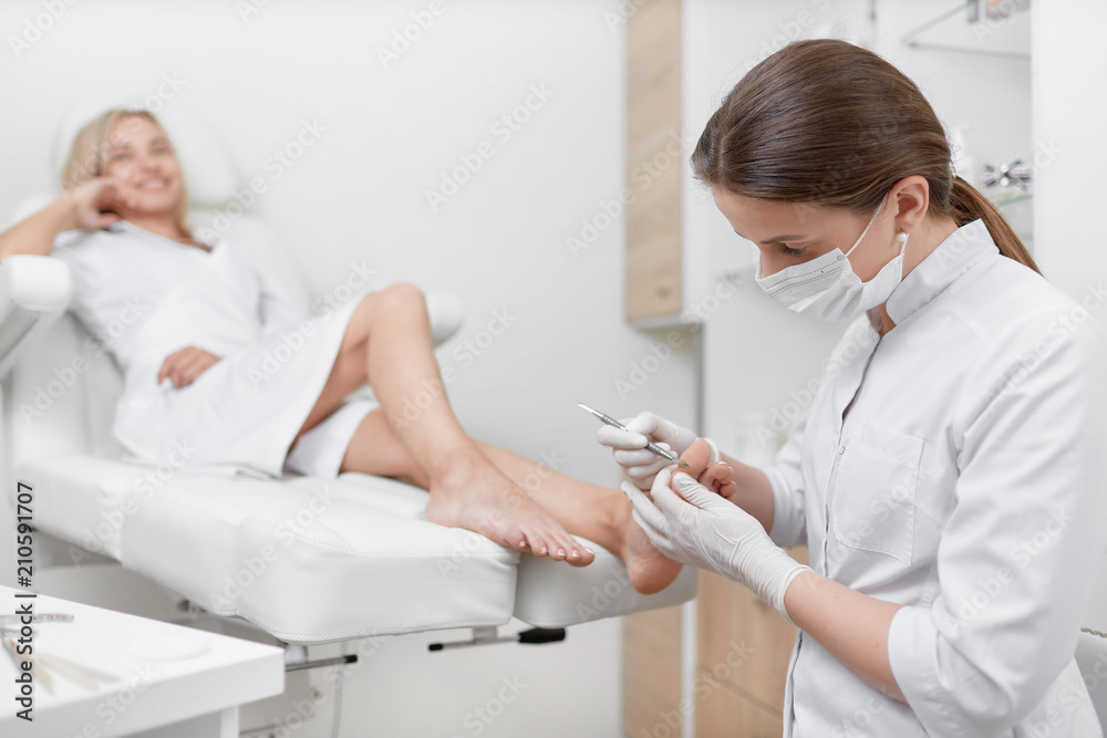Obraz premium Podiatrist doctor cleaning foot from callus.